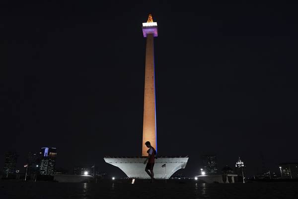 Warga berolah raga dengan latar belakang Tugu Monas di Jakarta, Jumat (4/8). Monas disorot lampu warna ASEAN hingga 8 Agustus 2017 untuk memperingati 50 tahun dibentuknya lembaga kerjasama negara-negara kawasan Asia Tenggara. ANTARA FOTO/Wahyu Putro A - ama