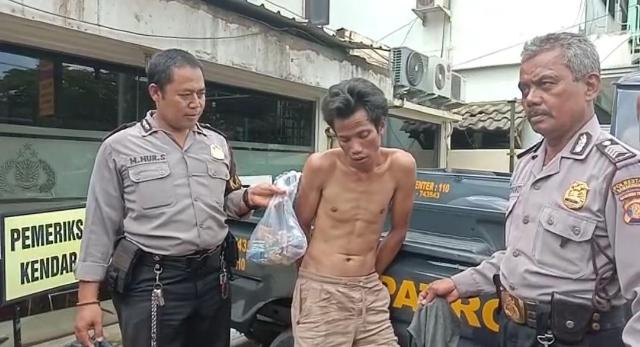 I Wama (tengah) ditangkap petugas setelah diamuk warga lantaran kedapatan mencuri kotak amal masjid. (Istimewa/Dok Polsek Sungai Pinang)